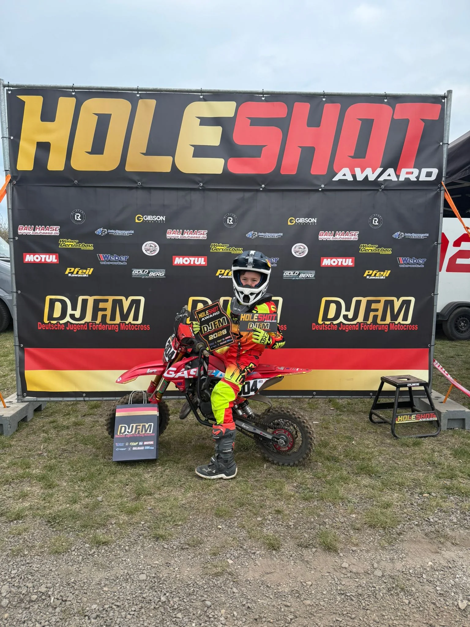 Jonas Hagert #304 mit Holeshot Award vor DJFM-Backdrop